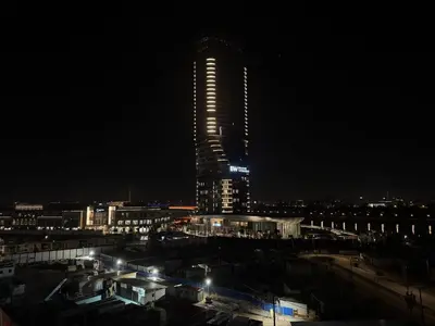 a tall skyscraper with lights on it at night at Bw Lux Apartments River view in Belgrade