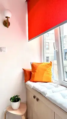 a window seat in a room with orange and yellow pillows at NookLite Studio near Belgrade Arena in Belgrade