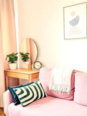 a pink couch in a living room with a mirror at NookLite Studio near Belgrade Arena in Belgrade