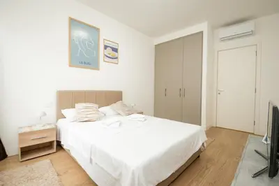 a bedroom with a white bed and a television at BW Terra Lux in Belgrade