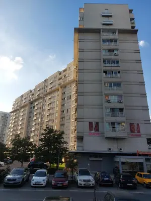 a tall building with cars parked in a parking lot at DELTA CITY apartments in Novi Beograd