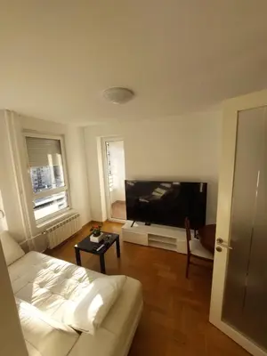 a living room with a bed and a flat screen tv at DELTA CITY apartments in Novi Beograd