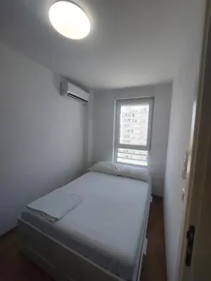 a small room with a bed and a window at DELTA CITY apartments in Novi Beograd