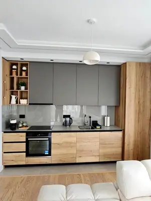 a kitchen with gray cabinets and a white couch at Belgrade Waterfront Primestay in Belgrade