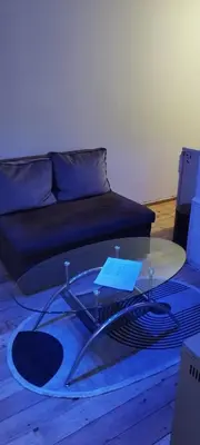 a living room with a table and a couch at Small Apartment private bathroom ,strong internet in Belgrade