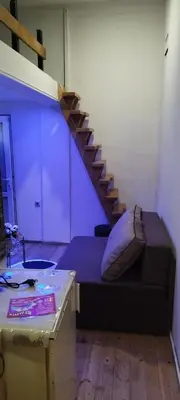 a room with a bed with a staircase in the background at Small Apartment private bathroom ,strong internet in Belgrade