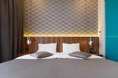 a bedroom with a bed with white sheets and pillows at Five Points Square - City Center in Belgrade