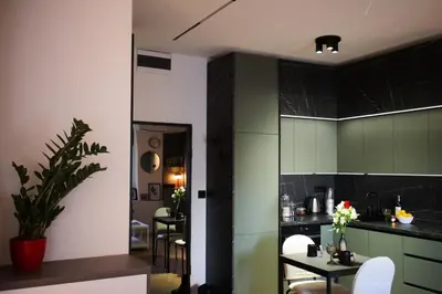 a kitchen with green cabinets and a table and chairs at Center Luxury Studio Knez Mihailova & Kalemegdan in Belgrade