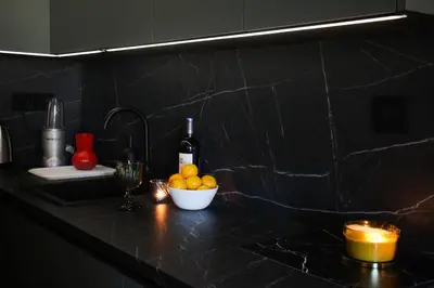 a kitchen counter with a bowl of fruit and a bottle of wine at Center Luxury Studio Knez Mihailova & Kalemegdan in Belgrade