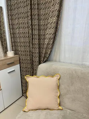 a couch with a pillow in front of a curtain at Guesthouse Vladimir & Ana in Pančevo