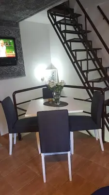 a dining room with a table and chairs and a staircase at Guesthouse Vladimir & Ana in Pančevo
