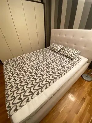a bed with a black and white comforter and a pillow at apartman the one - free parking in Belgrade