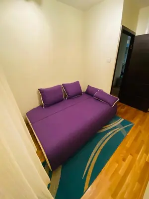 a bed in a room with purple pillows on the floor at apartman the one - free parking in Belgrade
