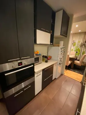a kitchen with black cabinets and a white refrigerator at apartman the one - free parking in Belgrade