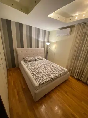 a bed in a room with a striped wall at apartman the one - free parking in Belgrade