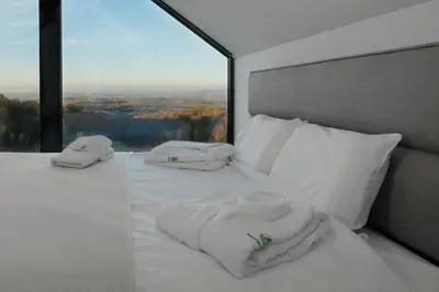 a bed with white sheets and pillows with a window at Oasis Pool House