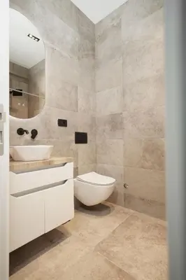 a bathroom with a toilet and a sink and a mirror at Oasis Pool House