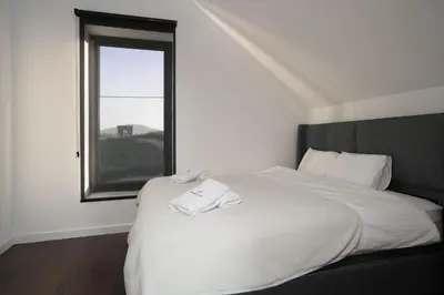 a bedroom with a white bed with a window at Oasis Pool House