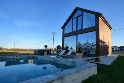 a house with a swimming pool next to a building at Oasis Pool House