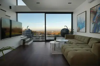 a living room with a couch and a large window at Oasis Pool House