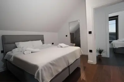 a white bedroom with a large bed and a mirror at Oasis Pool House