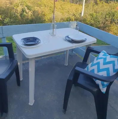 a white table and two chairs with a vase on it at Pure nature lovely view house in Zaklopača
