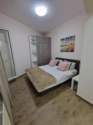a bedroom with a large bed with pink pillows at Belgrade Dawn Apartment in Belgrade