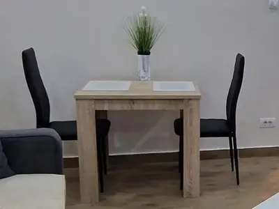 a table with two chairs and a vase with a plant on it at Belgrade Dawn Apartment in Belgrade