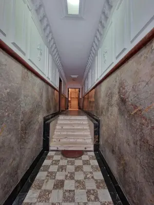 a hallway with a checkerboard floor in a building at Belgrade Dawn Apartment in Belgrade
