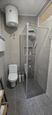 a bathroom with a toilet and a glass shower at Belgrade Dawn Apartment in Belgrade