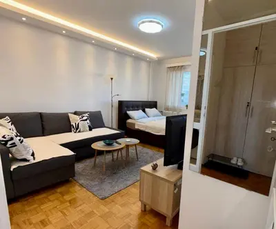 a living room with a couch and a bed at Bright Elegant Cozy Apartment - New Belgrade in Beograd