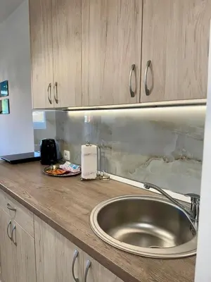 a kitchen counter with a stainless steel sink and cabinets at Bright Elegant Cozy Apartment - New Belgrade in Beograd