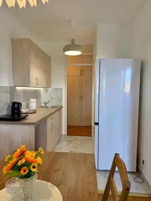a kitchen with a white refrigerator and a table with flowers at Bright Elegant Cozy Apartment - New Belgrade in Beograd