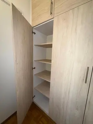 a closet with white cabinets and wooden shelves at Bright Elegant Cozy Apartment - New Belgrade in Beograd