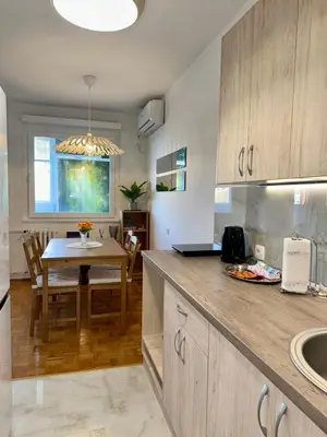 a kitchen with a table and a dining room at Bright Elegant Cozy Apartment - New Belgrade in Beograd