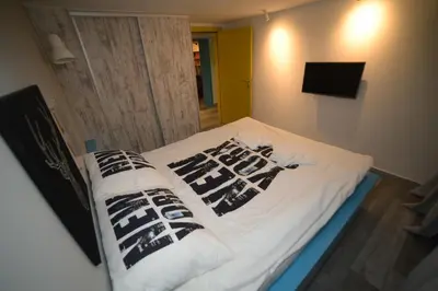 a bed with black and white pillows on it at City Place Apartments in Belgrade