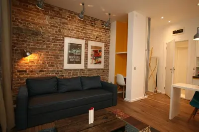 a living room with a couch against a brick wall at City Place Apartments in Belgrade