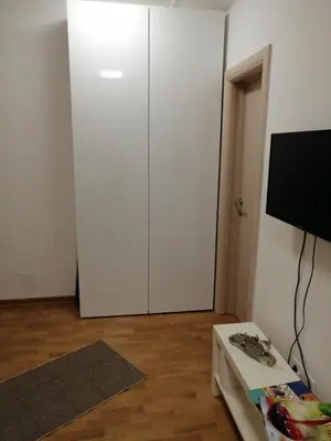 a white closet in a room with a tv at Soft Loft cozy studio with a garage parking place in Belgrade