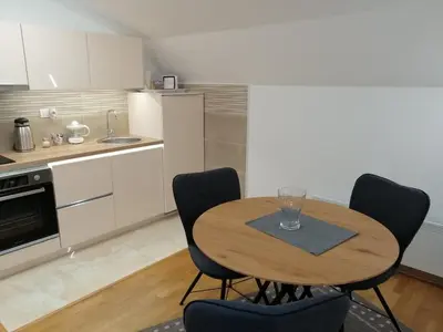 a kitchen with a table and chairs in a kitchen at Soft Loft cozy studio with a garage parking place in Belgrade