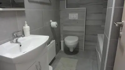 a bathroom with a white sink and a toilet at Soft Loft cozy studio with a garage parking place in Belgrade