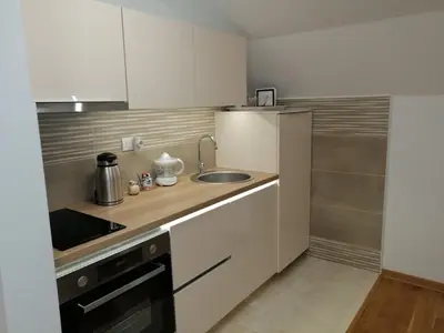 a small kitchen with a sink and a stove at Soft Loft cozy studio with a garage parking place in Belgrade