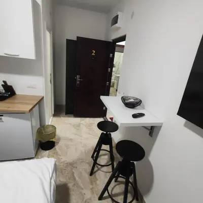 a room with two stools and a table and a bed at Hera Apartments in Belgrade