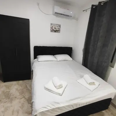 a bedroom with a white bed with towels on it at Hera Apartments in Belgrade