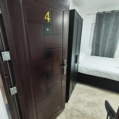 a door in a room with a bed and a bedroom at Hera Apartments in Belgrade