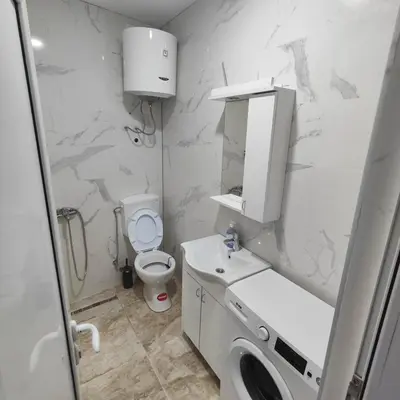a white bathroom with a toilet and a sink at Hera Apartments in Belgrade