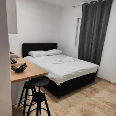 a small bedroom with a bed and a desk at Hera Apartments in Belgrade