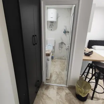 a small bathroom with a toilet and a table at Hera Apartments in Belgrade