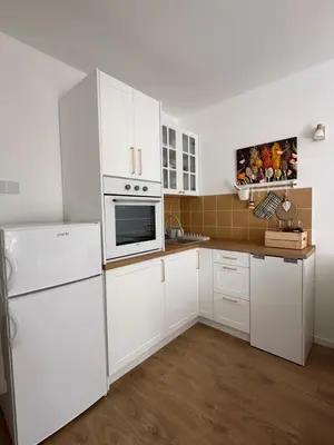 a kitchen with white cabinets and a white refrigerator at NiNiNo in Belgrade