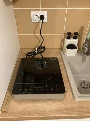 a plugged in stove in a kitchen with a charger at NiNiNo in Belgrade