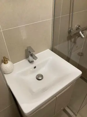 a white sink in a bathroom with a shower at NiNiNo in Belgrade